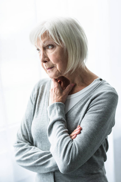 pensive senior woman in grey cardigan looking away - Foto, Bild