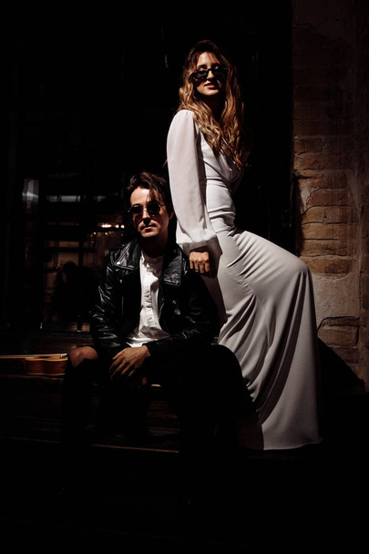 Beautiful young couple in sunglasses posing indoors - 写真・画像