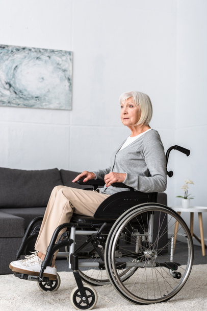disabled senior woman sitting in wheelchair and looking away - Fotografie, Obrázek
