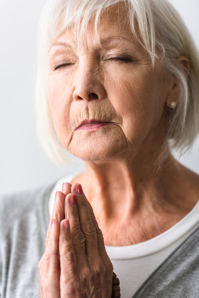 Seniorin zeigt bitte Geste und betet mit geschlossenen Augen  - Foto, Bild