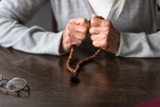 partial view of senior woman holding wooden rosary - Photo, Image