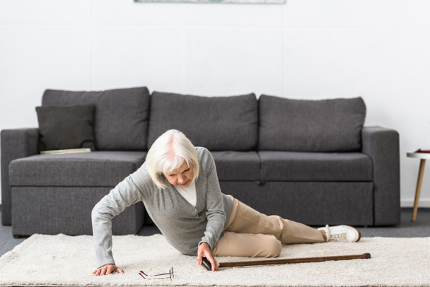 suffering senior woman with heart attack on carpet - Valokuva, kuva