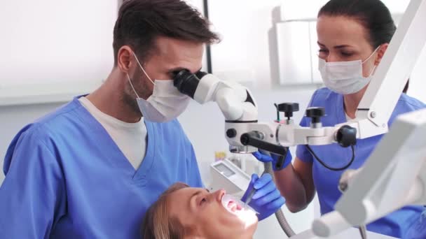 Male dentist looking through dental microscope - Video, Çekim