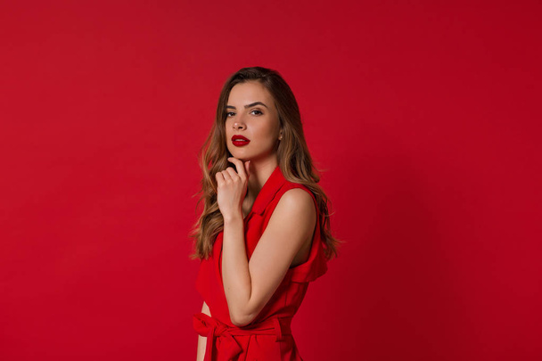 Kırmızı arka planda çarpıcı kadın model yüz ifadesi. Şık Avrupalı kızın yakın çekim portresi  - Fotoğraf, Görsel