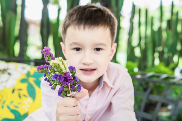 Boy enjoy playing with flower and cactus in a restaurant - boy happy with nature concept - Foto, immagini