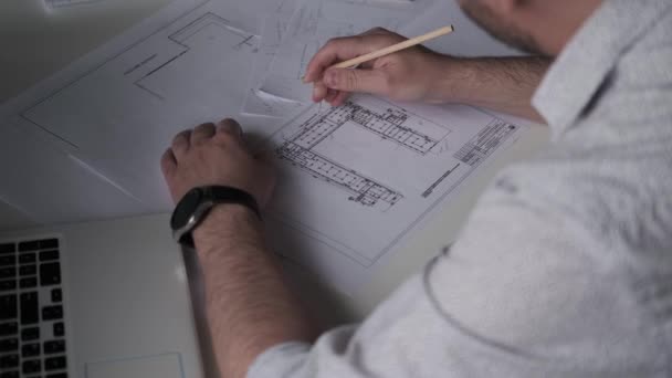 Architect works with blueprints and documents at his desk. back view. - Footage, Video