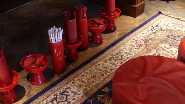 S předpovědí v orientálním chrámu. Vázy s tradičními tyčkami věštkyně Seam-si umístěné na podlaze v čínském chrámu před oltářem. Polštáře na kolenou na podlaze na koberci - Záběry, video