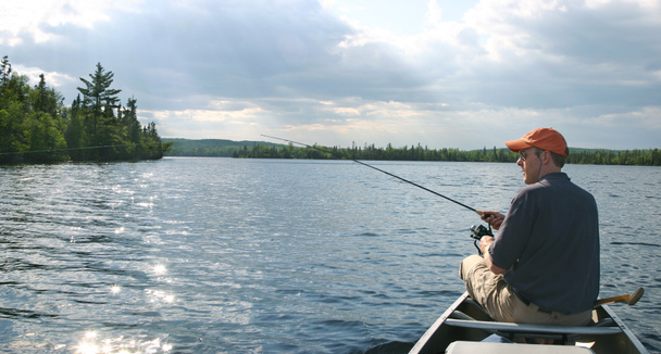 Uomo in canoa pesca sul lago del Minnesota settentrionale
 - Foto, immagini