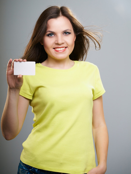 Attractive young woman in a yellow shirt. Woman holds a poster. - 写真・画像