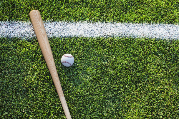 Baseball bat and ball on grass field viewed from above - Foto, Bild