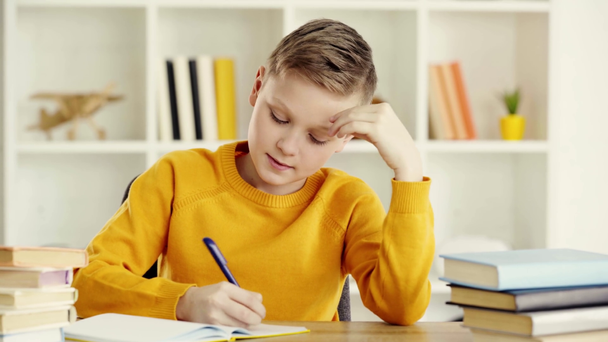 στοχαστικός μαθητής γράφοντας στο σημειωματάριο, αγγίζοντας το πρόσωπο και αναστενάζοντας στο σπίτι  - Πλάνα, βίντεο