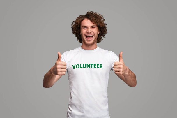 Cheerful volunteer gesturing thumb up - Foto, Bild