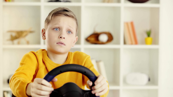 selektivní zaměření emocionálního školáku přidržující volant a stát se smutným po hraní videohry  - Záběry, video