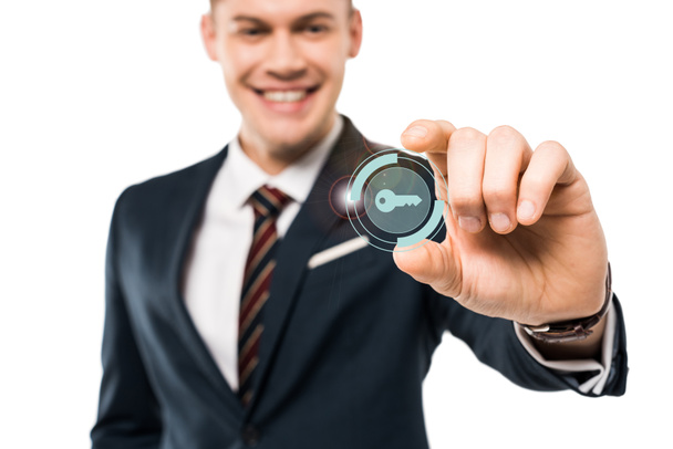 selective focus of happy businessman gesturing and smiling while touching virtual key icon isolated on while  - Foto, immagini