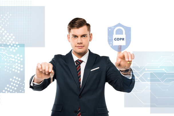 handsome man in suit holding keys and pointing with finger at virtual padlock with gdpr lettering on white   - Photo, Image