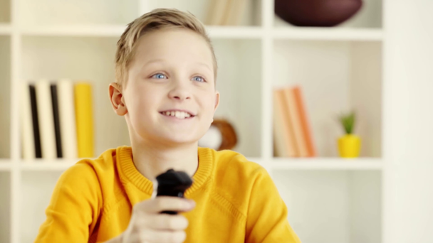 emocjonalne dziecko trzyma joystick i obchodzi triumf po grze wideo - Materiał filmowy, wideo