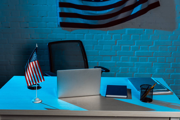 laptop near stationery near american flag in modern office  - Zdjęcie, obraz