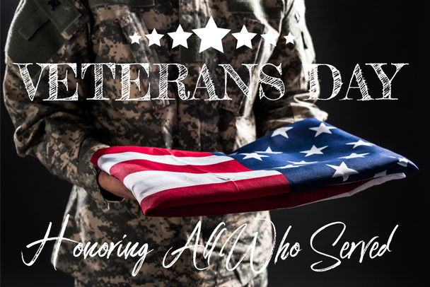 vista recortada del soldado en uniforme militar sosteniendo la bandera de América cerca de las letras del día de los veteranos en gris
  - Foto, Imagen