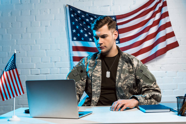 jóvágású katona-ban egyenruha használ laptop hivatalban  - Fotó, kép