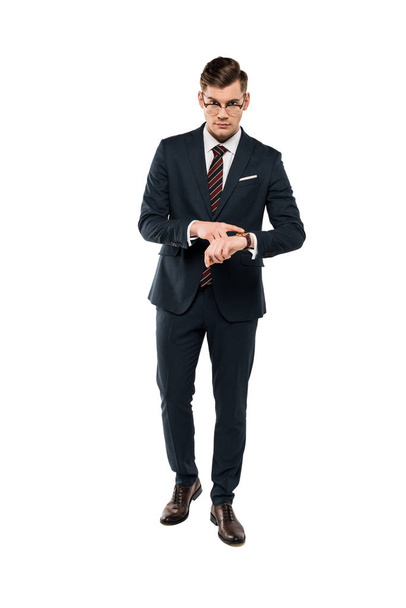 guapo hombre de negocios en gafas apuntando con el dedo al reloj aislado en blanco
  - Foto, Imagen