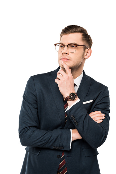 σκεπτικός επιχειρηματίας σε γυαλιά αγγίζοντας το πρόσωπο ενώ σκέφτονται απομονώνονται σε λευκό  - Φωτογραφία, εικόνα