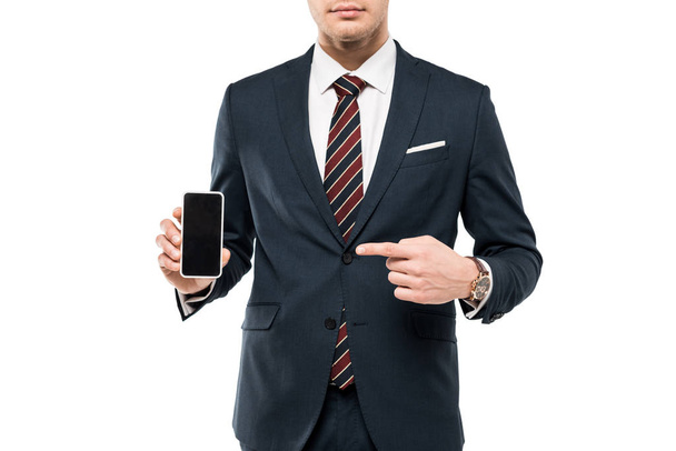 vista recortada del hombre de negocios en traje apuntando con el dedo al teléfono inteligente con pantalla en blanco aislado en blanco
  - Foto, Imagen