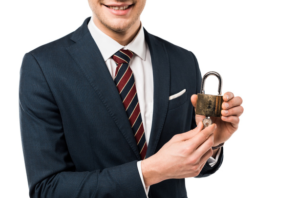 cropped view of happy businessman in suit holding keys and padlock isolated on white  - Φωτογραφία, εικόνα