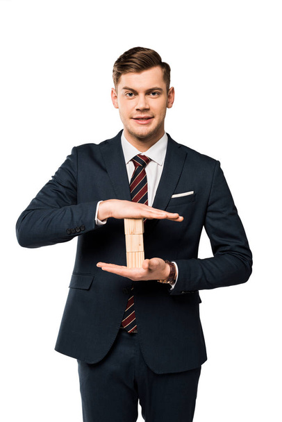 cheerful businessman in suit holding wooden cubes isolated on white  - Zdjęcie, obraz