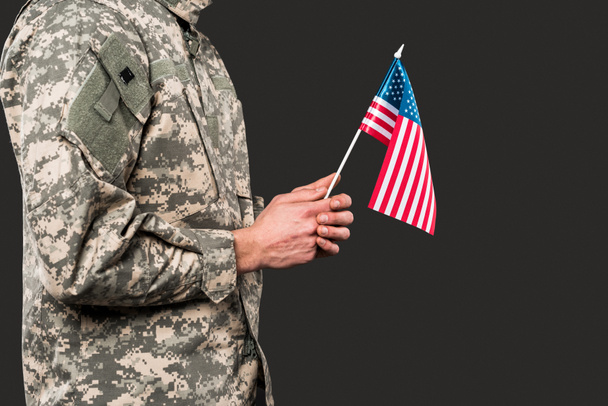 vista recortada de soldado sosteniendo bandera americana aislado en gris
  - Foto, Imagen