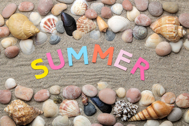 Nápis léto od novin s vícebarevnými písmeny a mušlí a letní výbavou na mořském písku. Letní. Relaxační. Dovolenou. pohled shora - Fotografie, Obrázek