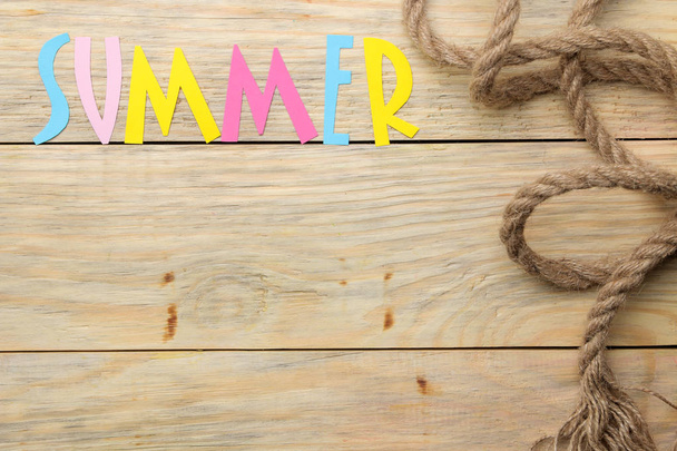 The word summer made of paper multicolored letters and sea rope on a natural wooden background. summer. vacation. relaxation. top view - Photo, Image