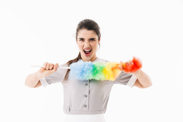Φωτογραφία της Καυκάσιος υπηρέτρια 20s ντυμένος σε ομοιόμορφη κρατώντας πολύχρωμα  - Φωτογραφία, εικόνα