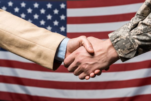 selektywne skupić mężczyzn drżenie rąk w pobliżu amerykańskiej flagi  - Zdjęcie, obraz