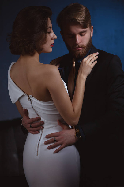 a girl with a gentle look put her hand on the shoulder of a man in love with her who holds her gently by the waist - Фото, изображение
