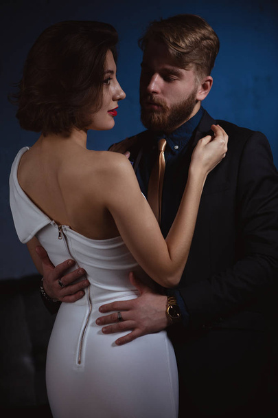 a man in love embraces a woman who smiles and looks slyly to the side - Foto, afbeelding
