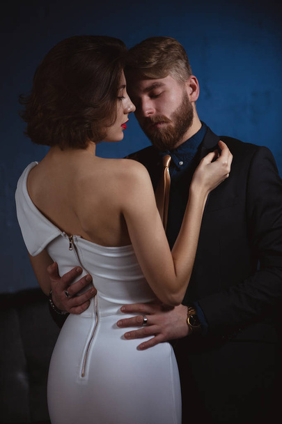 a girl with a gentle look put her hand on the shoulder of a man in love with her who holds her gently by the waist - Фото, изображение