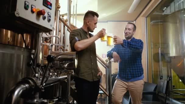 Twee mannen die vers bier proeven in een brouwerij - Video