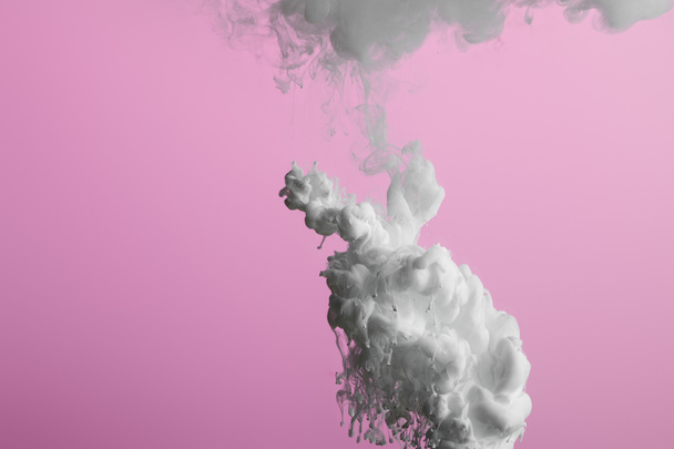 Close up view of white paint swirls isolated on pink - Φωτογραφία, εικόνα