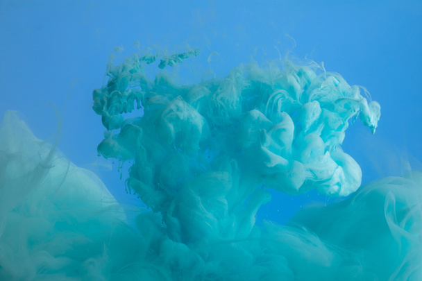 Close up view of turquoise paint swirls isolated on blue - Φωτογραφία, εικόνα