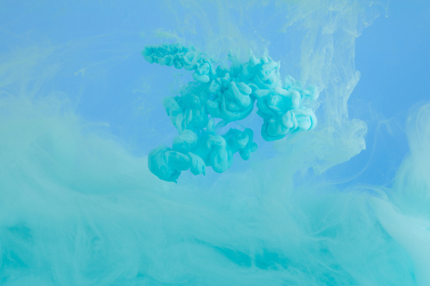 Close up view of turquoise smoky paint isolated on blue - Photo, Image