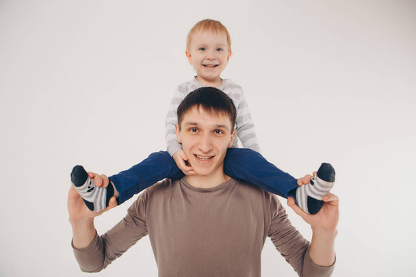 Papá sostiene al bebé en sus brazos. El concepto de educar al padre de los niños pequeños, la infancia feliz, una familia amigable
. - Foto, imagen