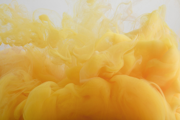 Vue rapprochée de peinture aquarelle orange clair mélangeant dans l'eau
 - Photo, image