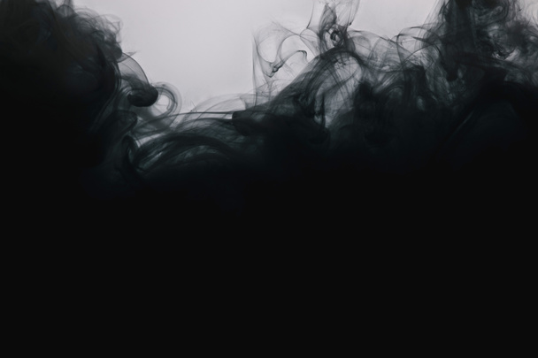 Vue rapprochée de tourbillons de peinture noirs isolés sur gris
  - Photo, image