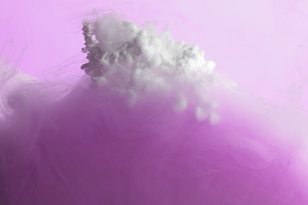 Vista de cerca de la mezcla de pintura rosa y blanca en agua aislada en rosa
 - Foto, imagen