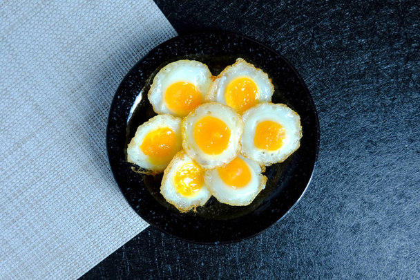 Smažené křepelové vajíčko na černém pozadí - Fotografie, Obrázek
