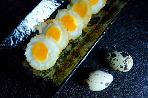 Smažené křepelové vajíčko na černém pozadí - Fotografie, Obrázek