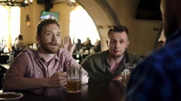 Wesoła przyjaciele picie piwa z beczki w pubie - Materiał filmowy, wideo