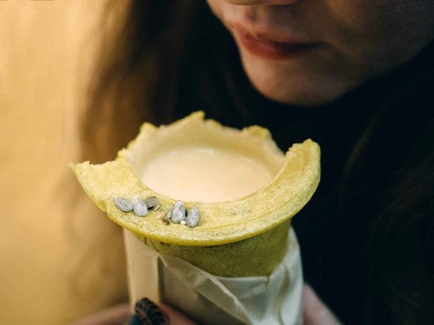 Cream soup in edible cup from bread. Hands - Photo, Image