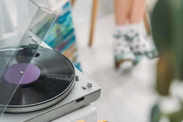 partial view of girl in dotted socks and record player with vinyl disc - Fotoğraf, Görsel