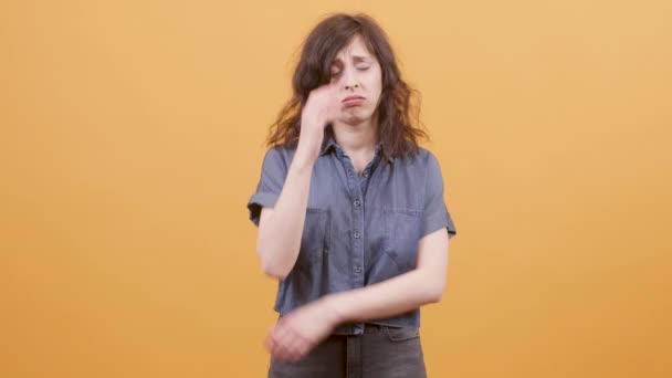 Young women looking worried or upset over a yellow background - Video